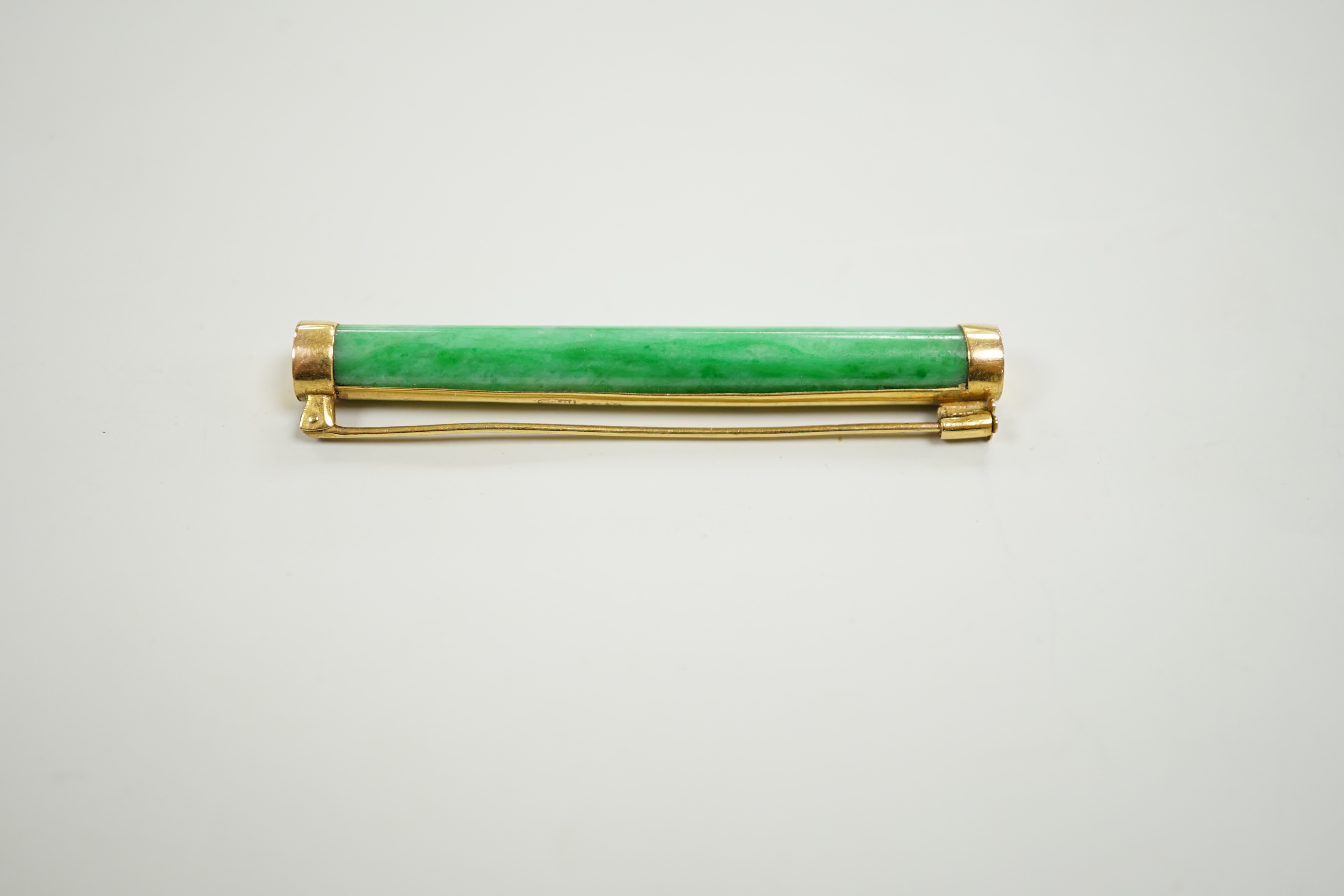 A Chinese yellow metal and cylindrical jade set bar brooch, 53mm, gross 5.6 grams.